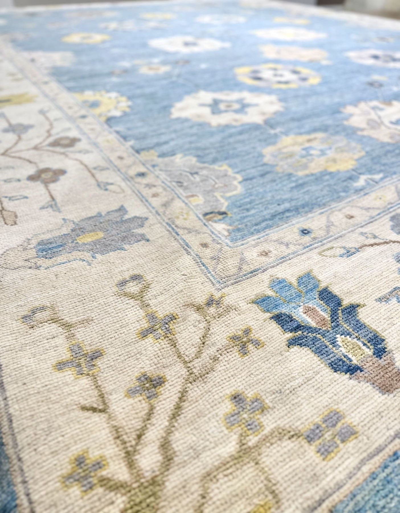 Classic Oushak hand-knotted rug. Crisp blue background with accents of navy, buttercup, sage, and ivory. Exact size 12'2" x 15'2". Fine quality luxury rug.