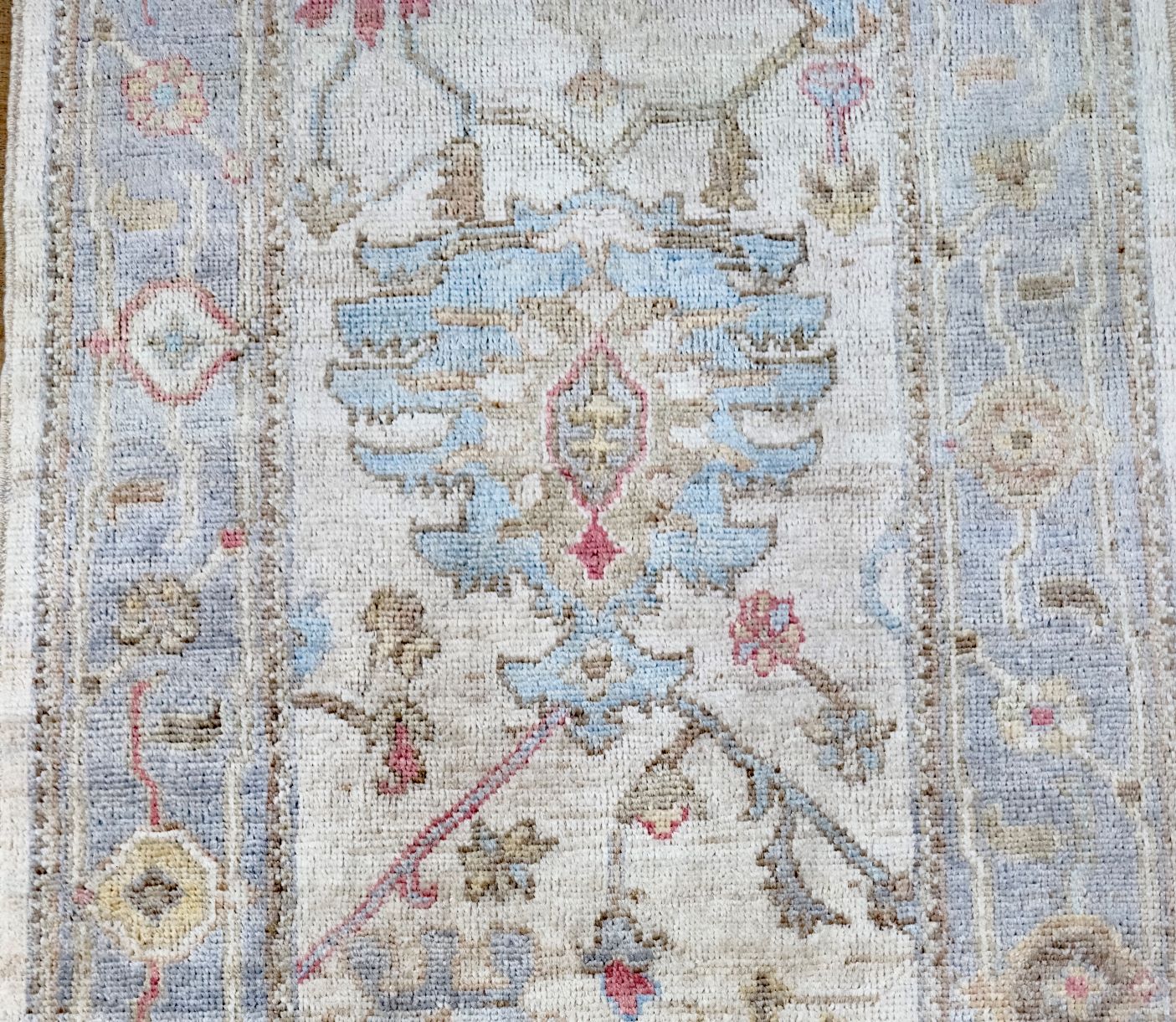 Knotted Couture hand knotted wool oushak runner in colors of blue, ivory, beige, rust, and camel