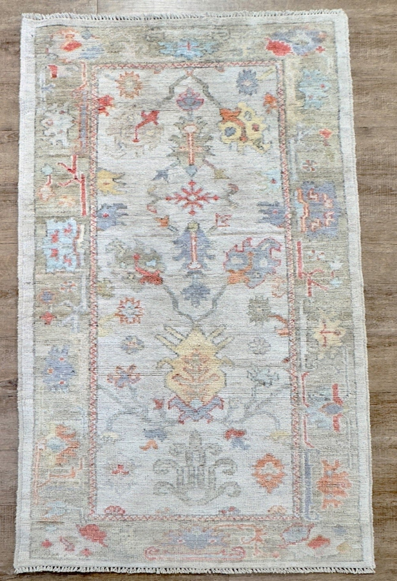 Knotted Couture hand knotted oushak style wool runner is soft shades of blue, gold, rust, sage, and ivory