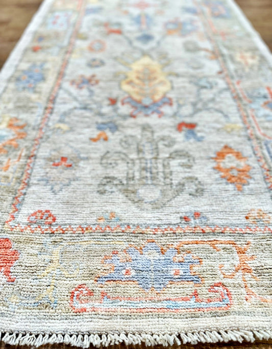 Knotted Couture hand knotted oushak style wool runner is soft shades of blue, gold, rust, sage, and ivory