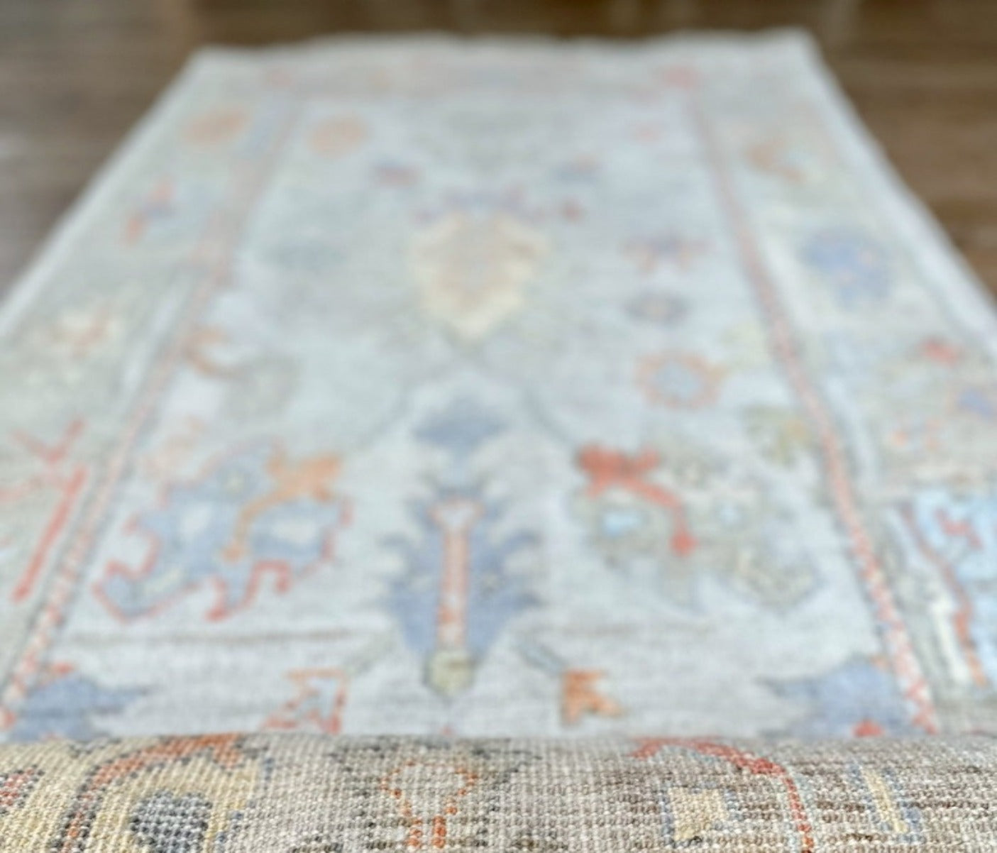 Knotted Couture hand knotted oushak style wool runner is soft shades of blue, gold, rust, sage, and ivory