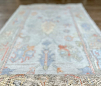 Knotted Couture hand knotted oushak style wool runner is soft shades of blue, gold, rust, sage, and ivory