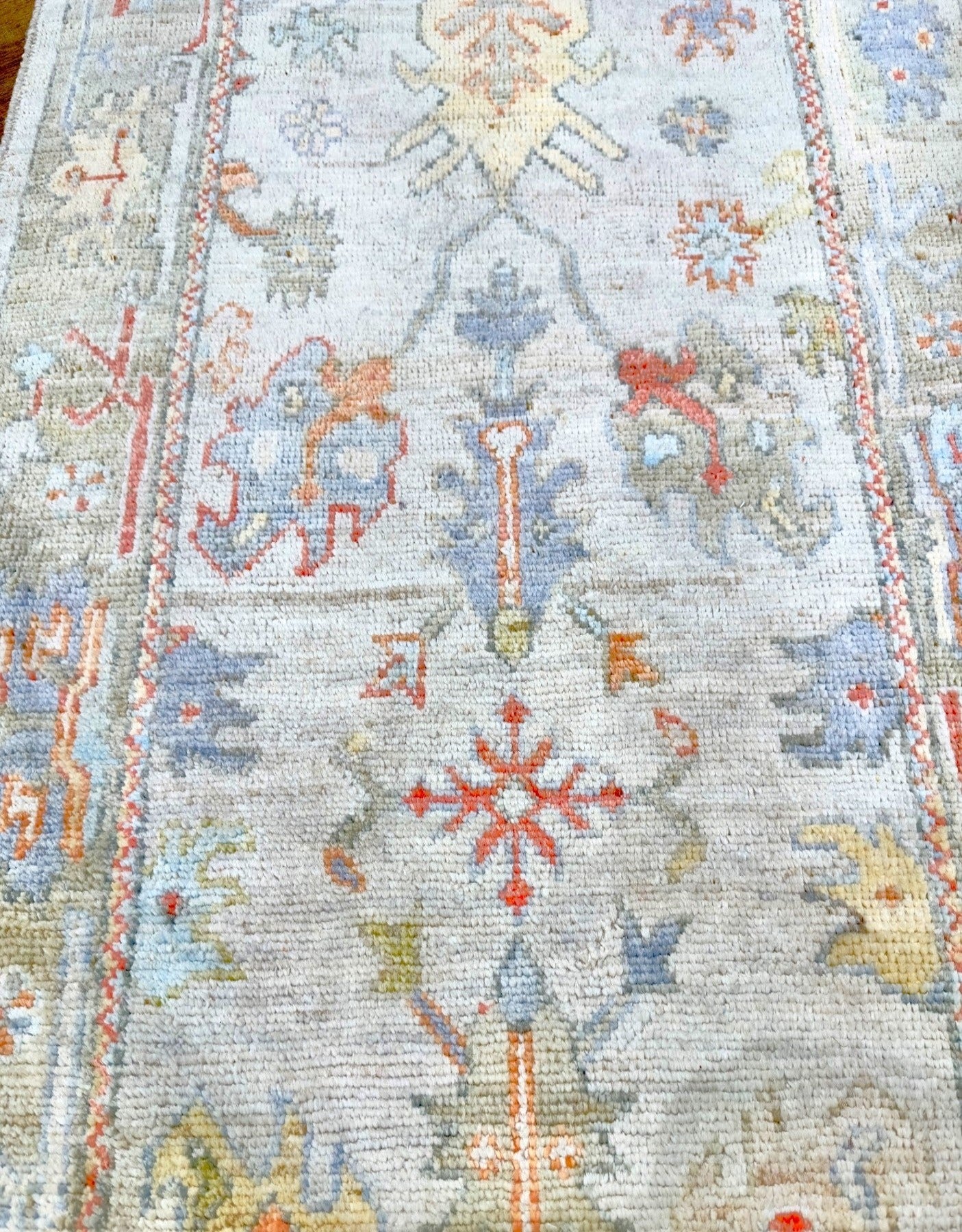 Knotted Couture hand knotted oushak style wool runner is soft shades of blue, gold, rust, sage, and ivory
