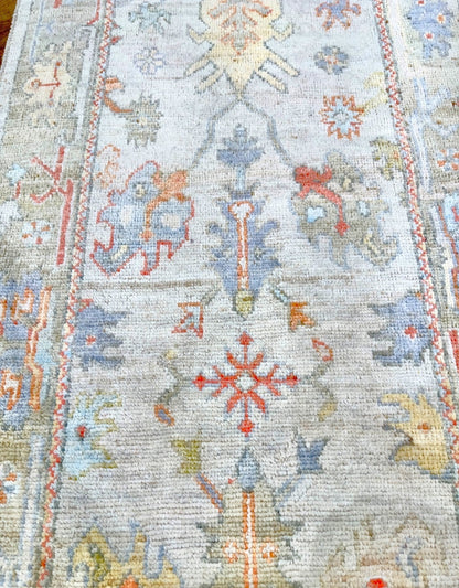 Knotted Couture hand knotted oushak style wool runner is soft shades of blue, gold, rust, sage, and ivory