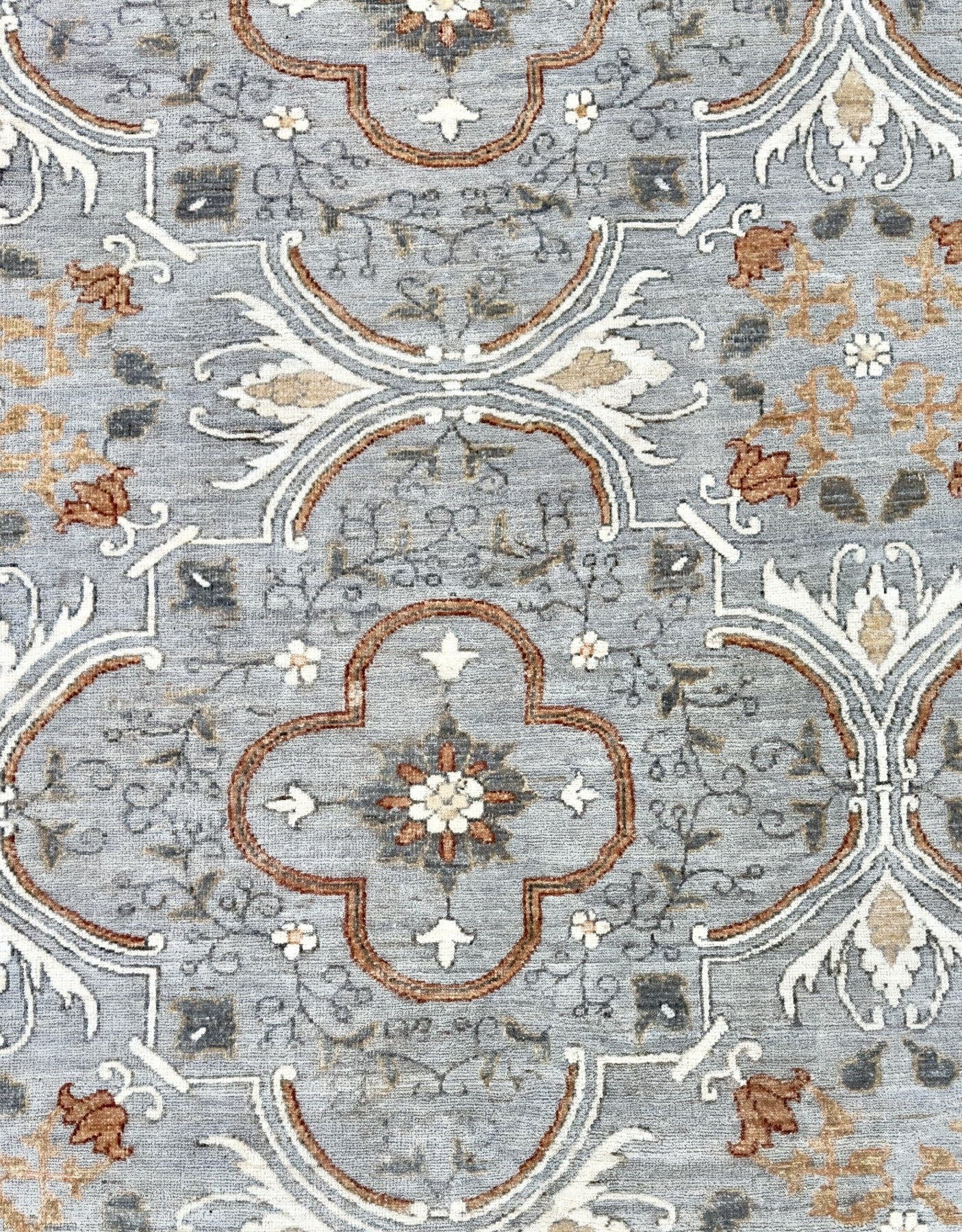 Knotted Couture hand knotted luxury rug in shades of gray, cream, and paprika