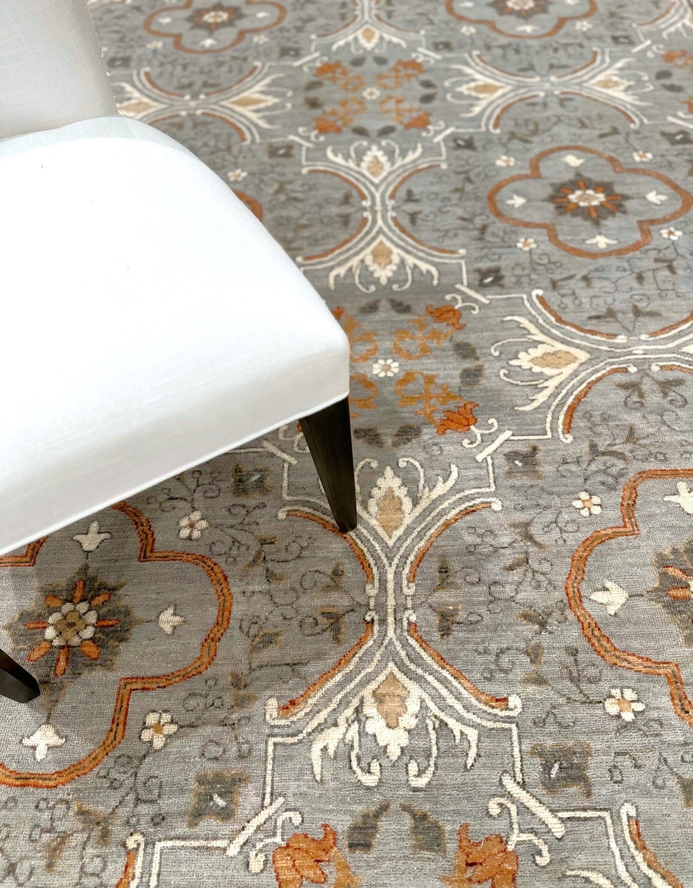 Knotted Couture hand knotted luxury rug in shades of gray, cream, and paprika