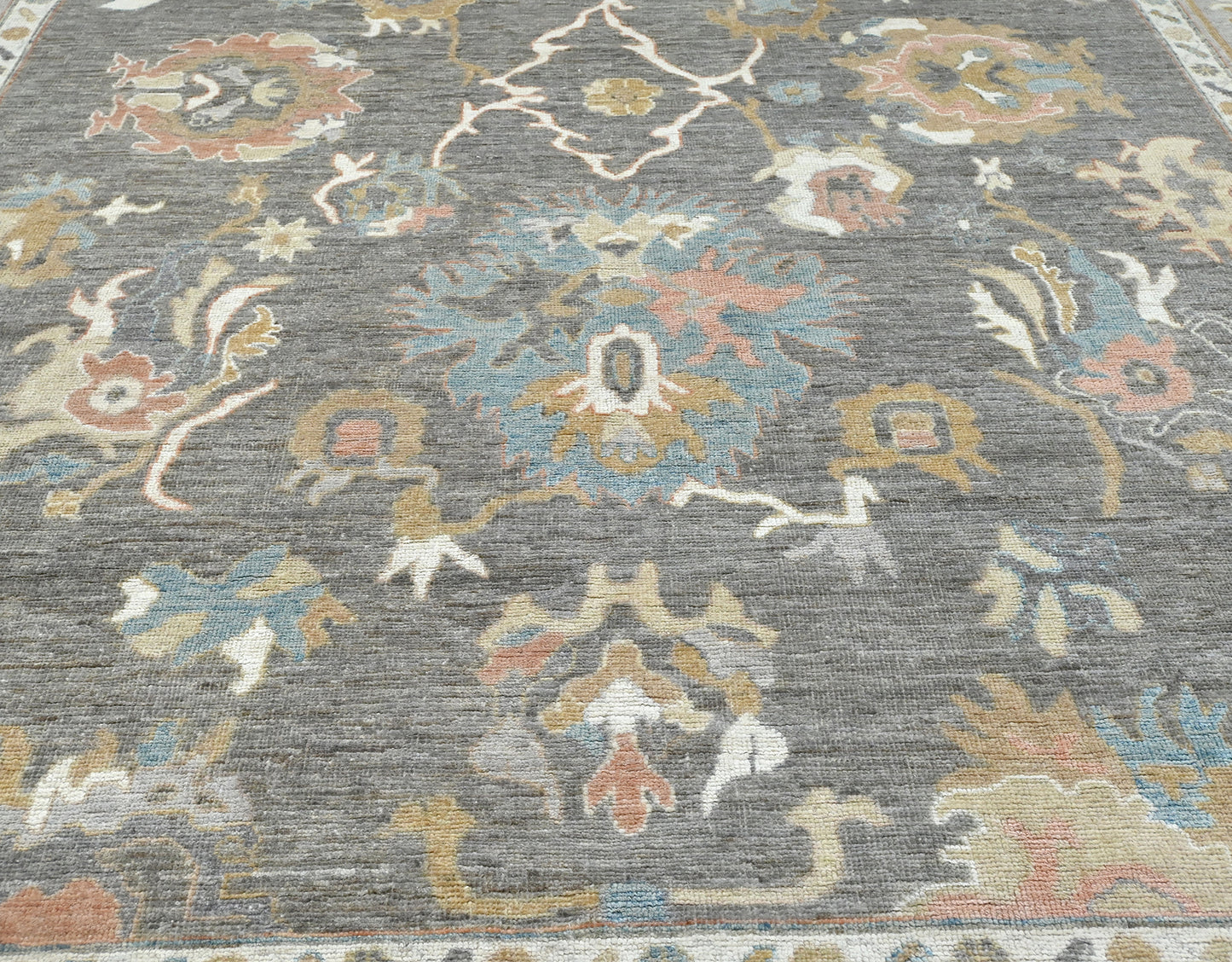 Modern gray oushak with rose, blue,caramel, and ivory. 9x12 rug