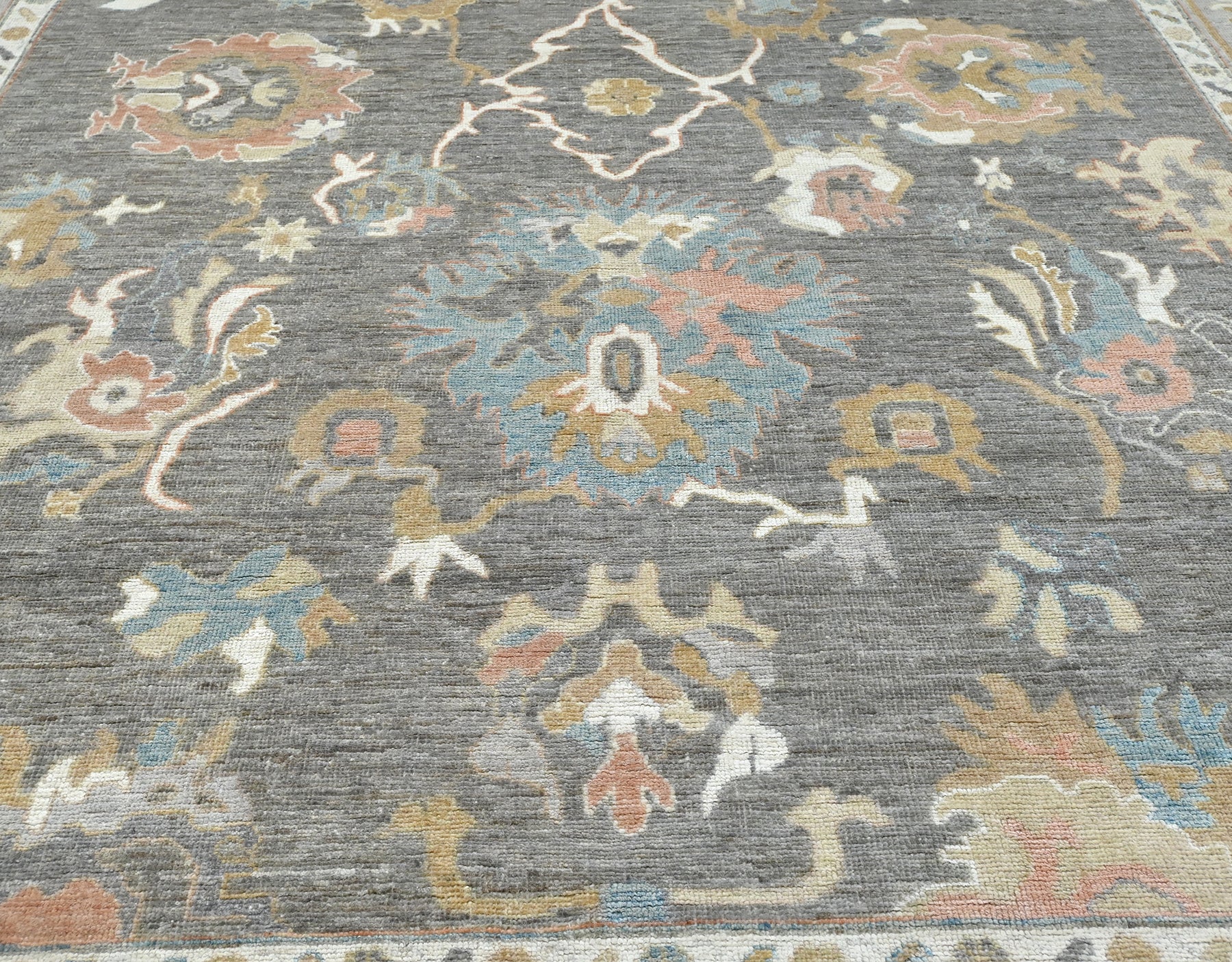 Modern gray oushak with rose, blue,caramel, and ivory. 9x12 rug