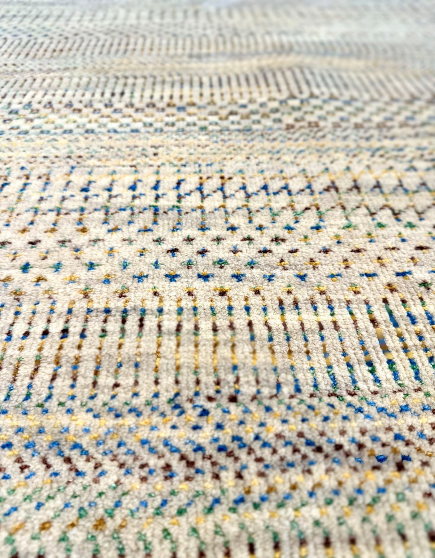 Neutral background wool hand knotted rug with jewel tone accents in a casual, modern palette.