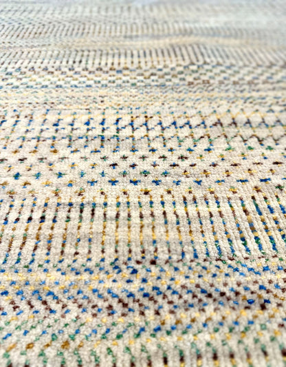 Neutral background wool hand knotted rug with jewel tone accents in a casual, modern palette.
