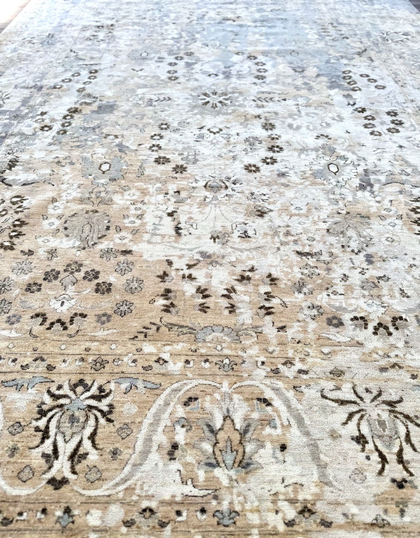 Luxury hand-knotted rug.  Made in Pakistan of 100% wool. Main colors of dark maduro, cream, beige, subtle blue. 10 x 14 wool rug.